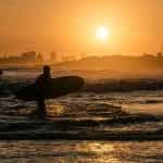 Playa y surfistas en la costa uruguaya.