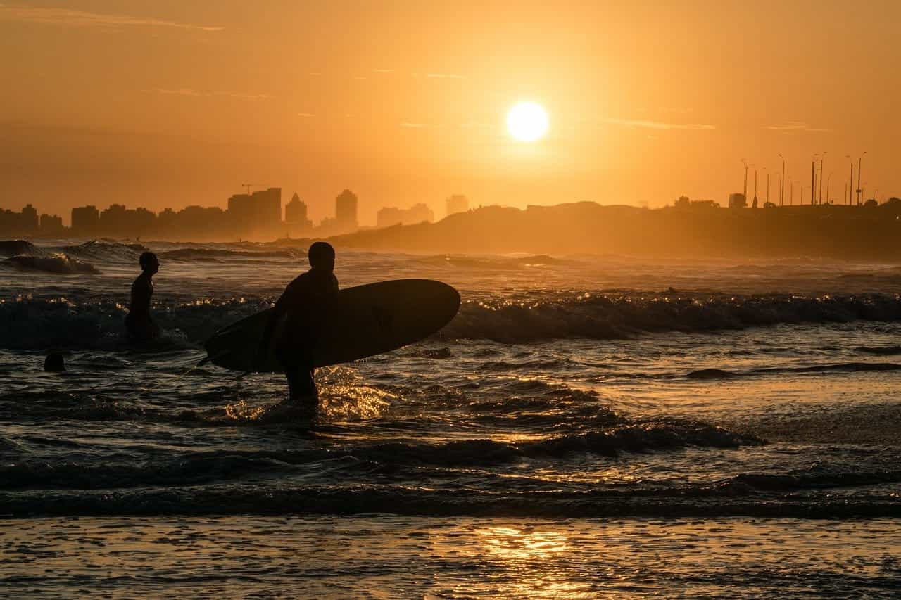 Playa y surfistas en la costa uruguaya.