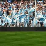 Aficcionados con banderas argentinas en un estadio de fútbol.