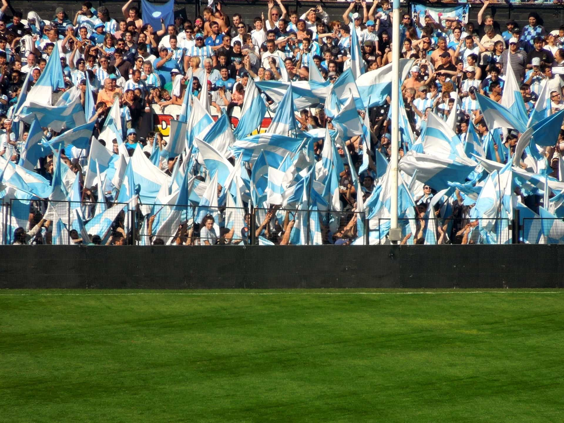 Aficcionados con banderas argentinas en un estadio de fútbol.