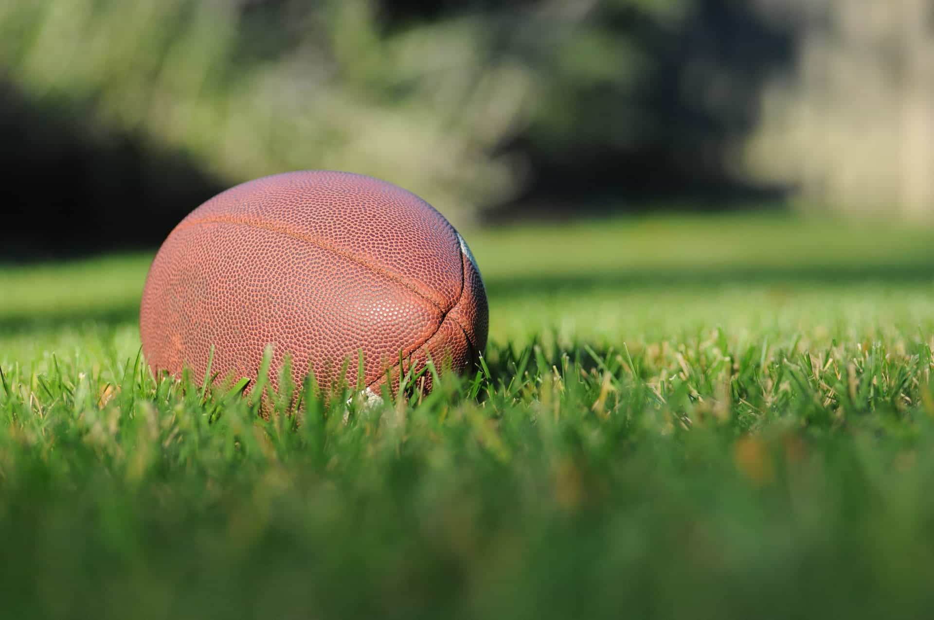 Pelota de fútbol americano sobre el césped.