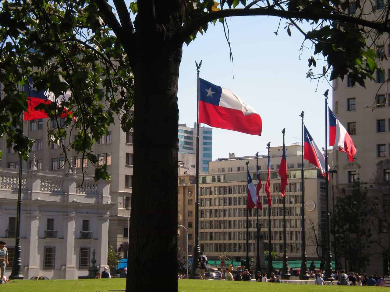 Banderas de Chile ondeando en plaza pública.