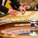 Persona poniendo fichas en mesa de ruleta en plena acción