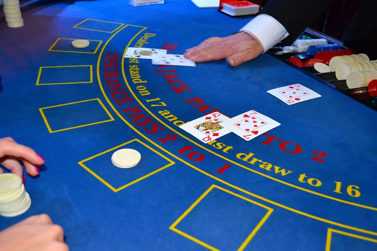 Crupier repartiendo cartas en una mesa de juego en un casino.