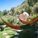 Hamacas con los colores de la bandera de Bolivia, dispuestas en la ladera de una montaña.