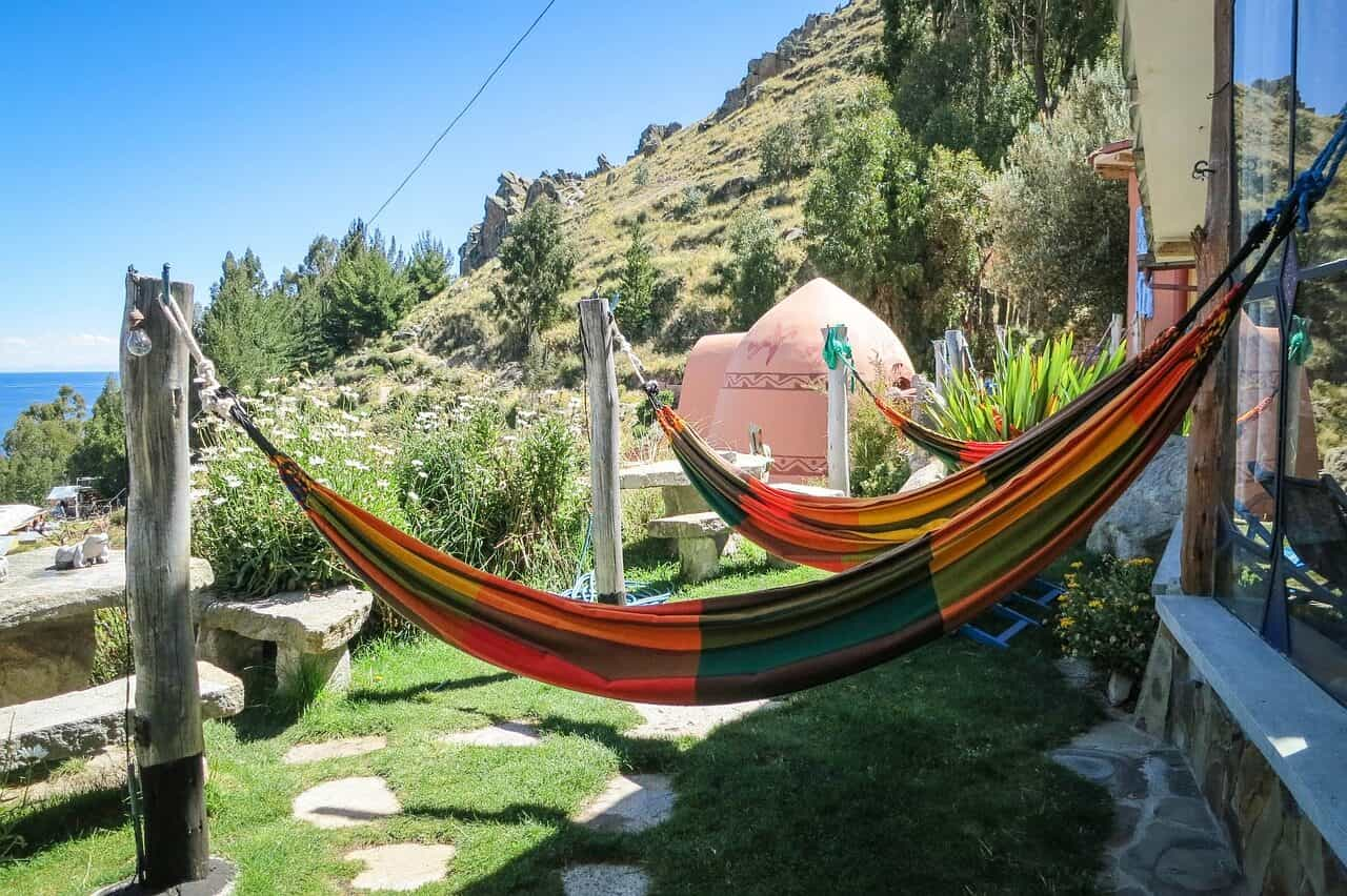 Hamacas con los colores de la bandera de Bolivia, dispuestas en la ladera de una montaña.