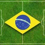 Bandera de Brasil sobre un gramado de fútbol.