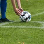 Jugador acomodando la pelota en el punto del tiro de esquina.