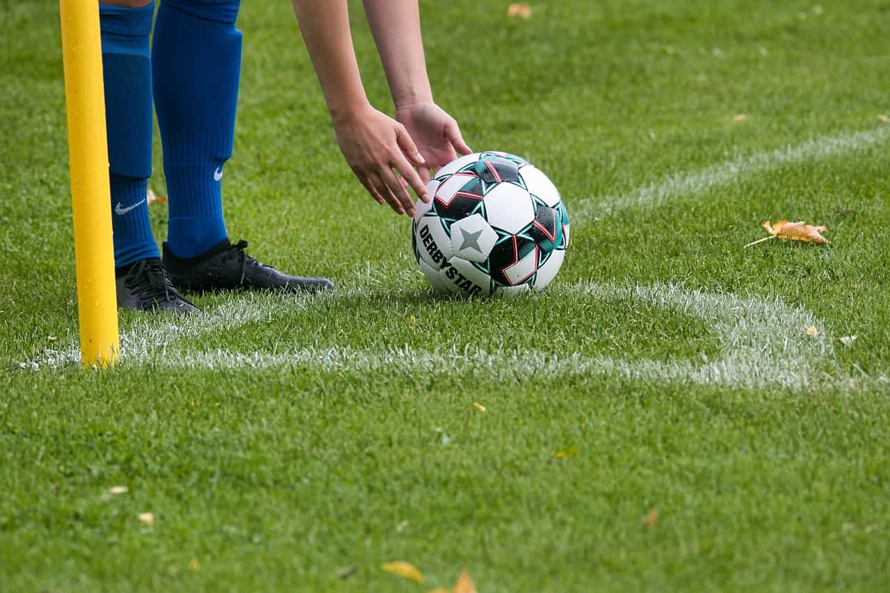 Jugador acomodando la pelota en el punto del tiro de esquina.