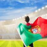 Persona con una bandera de Portugal en un estadio de fútbol.