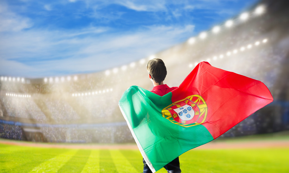 Persona con una bandera de Portugal en un estadio de fútbol.