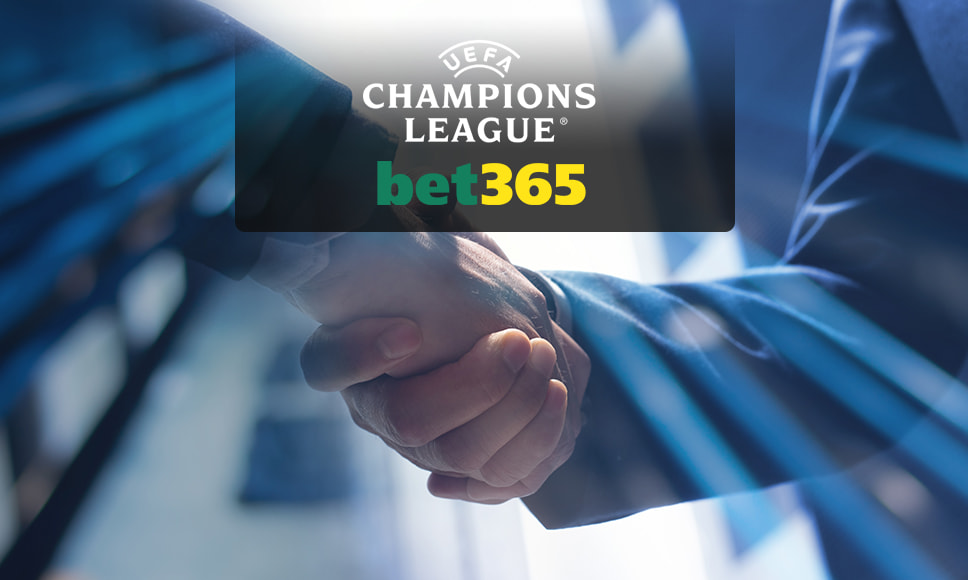 Dos ejecutivos dándose la mano con el logo de la UEFA Champions League y de bet365.