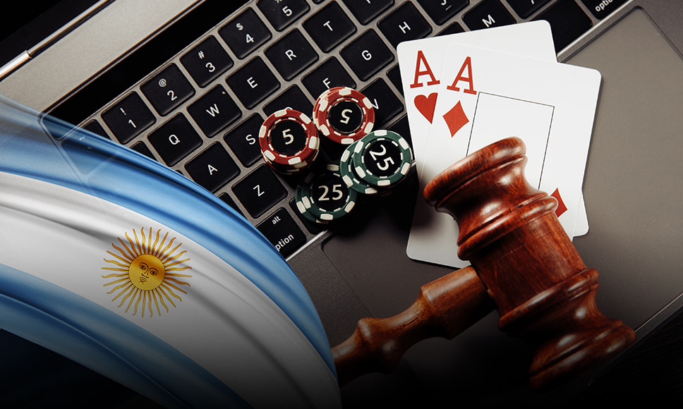 Teclado de un ordenador portátil con fichas y cartas de casino y bandera argentina.