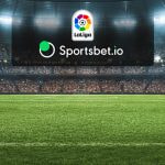 Estadio de fútbol con los logos de LaLiga y el operador Sportsbet.io.