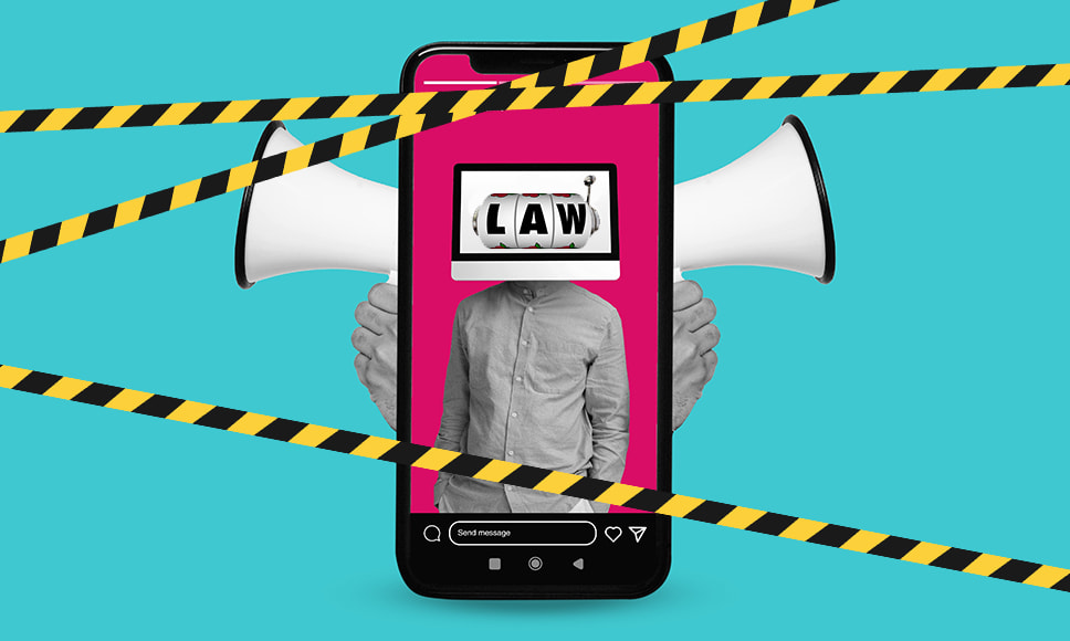 Celular con la palabra LAW en el tambor de una máquina tragamonedas y advertencia de prohibido el paso.